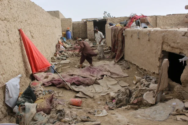 Locals inspect a damaged house following floods, landslides and thunderstorms in Kandahar province, Afghanistan, Sunday, March 29, 2026.
