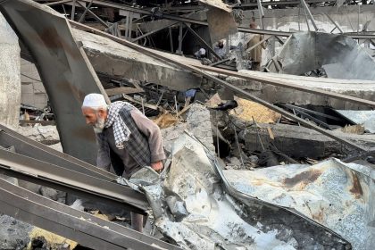 A man searches through the rubble of the destroyed Kabul hospital