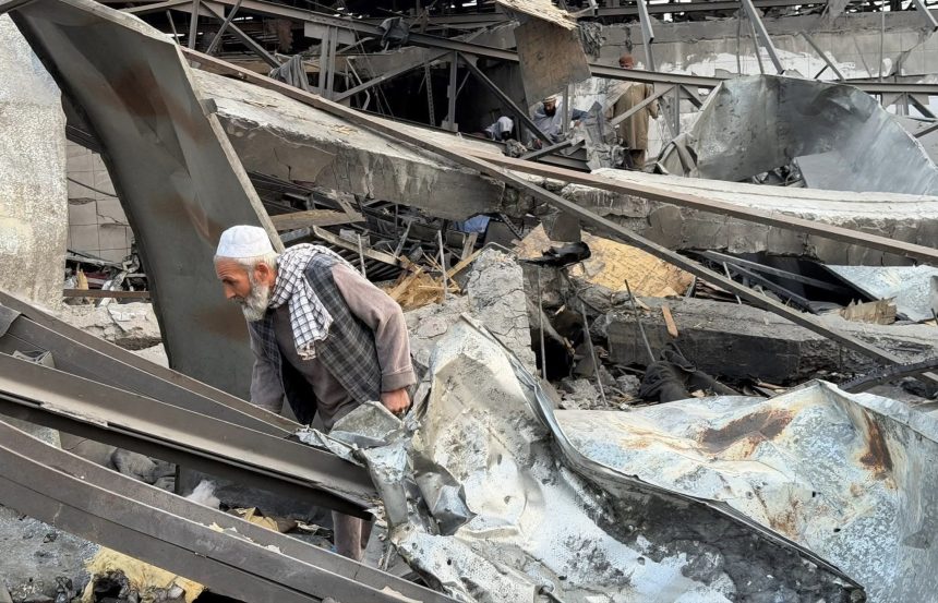 A man searches through the rubble of the destroyed Kabul hospital